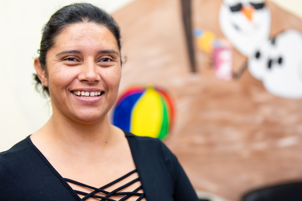 A spanish lady smiling after getting dental treatment for her and her kids at Regional Dental Center Jacksonville, AL